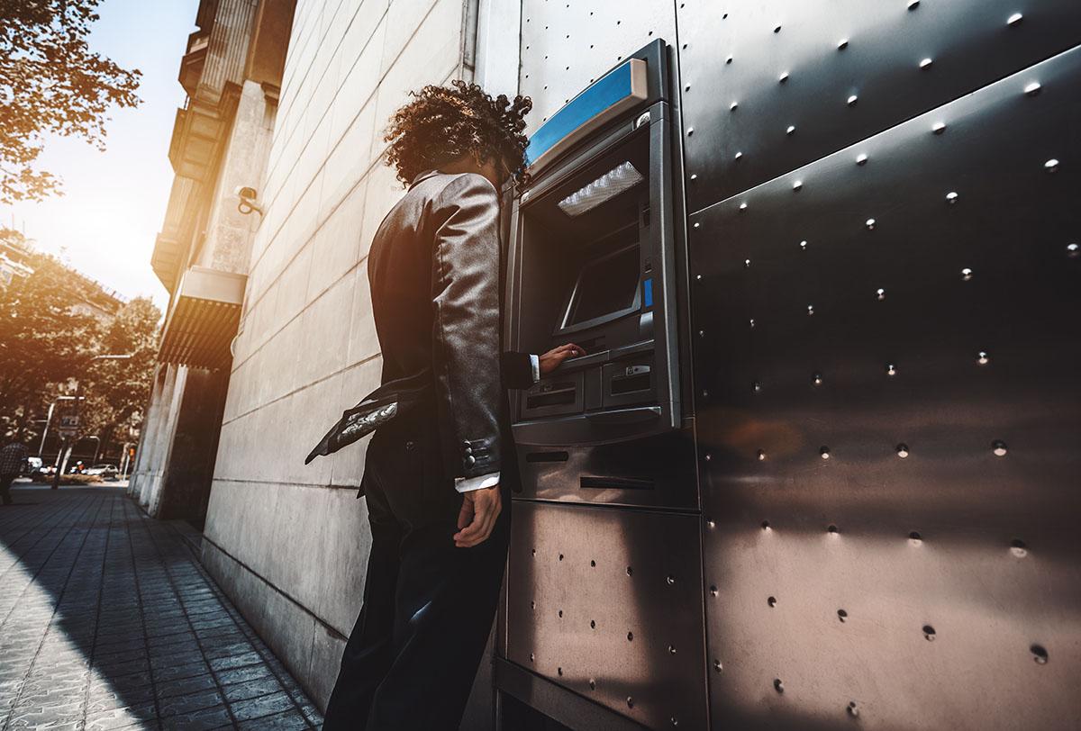 Un homme en costume utilisant un distributeur automatique de billets