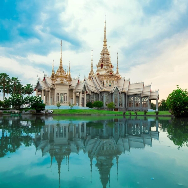  Temple magnifique en Thaïlande, avec une architecture élaborée et des détails artistiques impressionnants sous un ciel bleu.