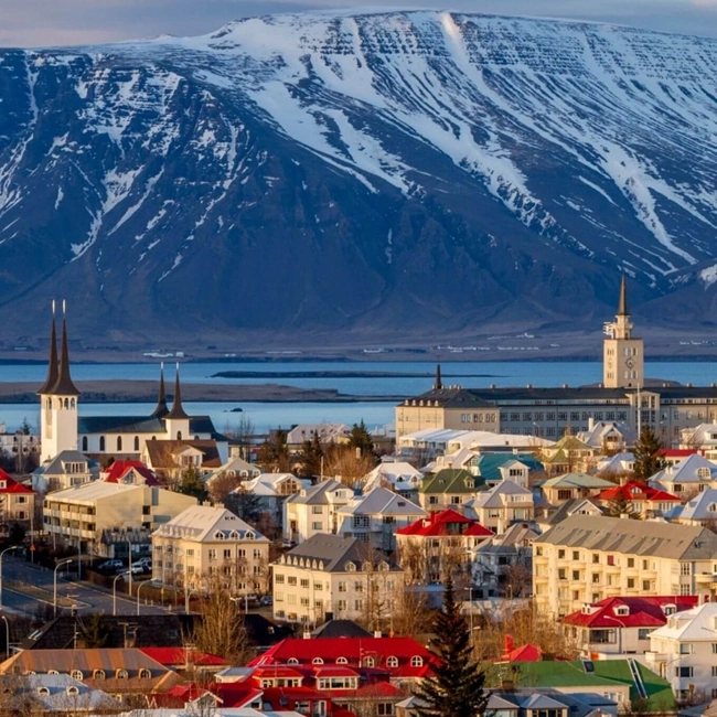 Panoramic view of Reykjavik, Iceland's capital, with its colorful buildings and mountainous landscape in the background.