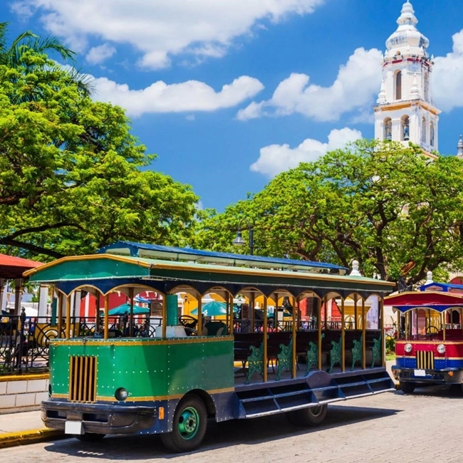 Tramways colorés circulant dans les rues animées de Carthagène, Colombie, illustrant la vie urbaine vibrante.