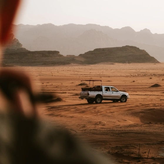 A woman taking a selfie while wearing a hat, smiling and capturing a moment of joy.