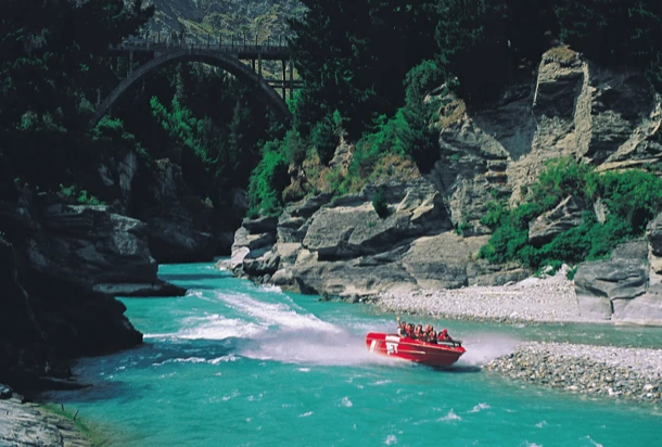 Une rivière tranquille avec un bateau naviguant paisiblement à sa surface, entourée de verdure luxuriante.