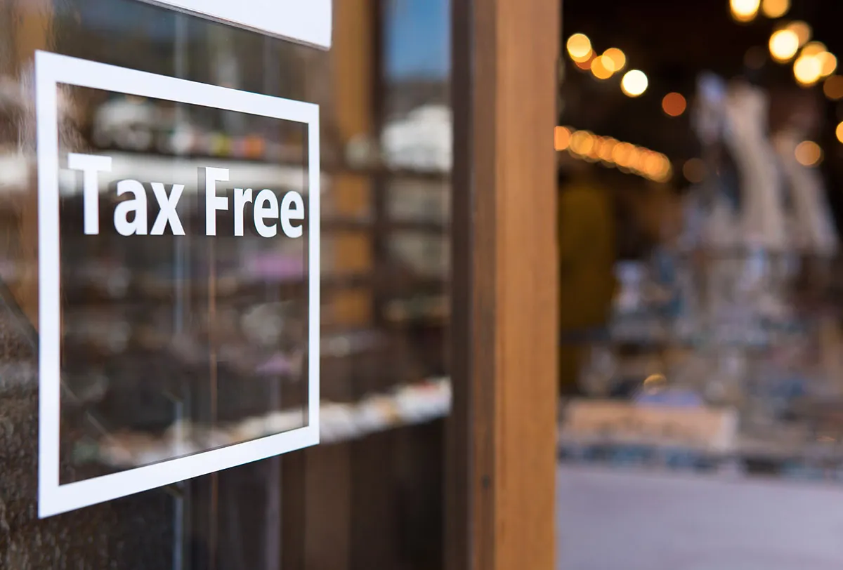 Un panneau dans une vitrine affichant « Tax Free », indiquant qu'aucune taxe n'est prélevée sur les achats effectués dans ce lieu.