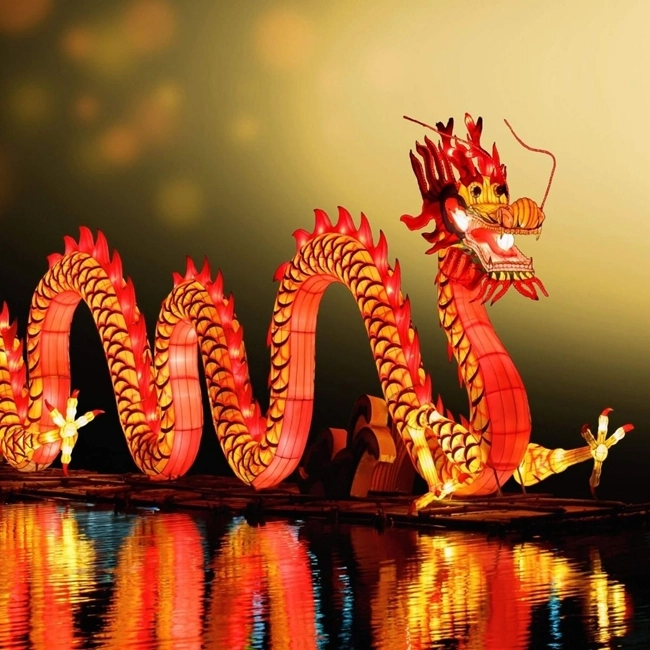 Chinese dragon lanterns float on water, illuminating the night with bright colors and traditional motifs.