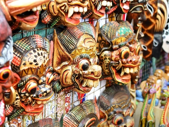 A variety of colorful masks displayed on one wall, illustrating the diversity of styles and cultures.