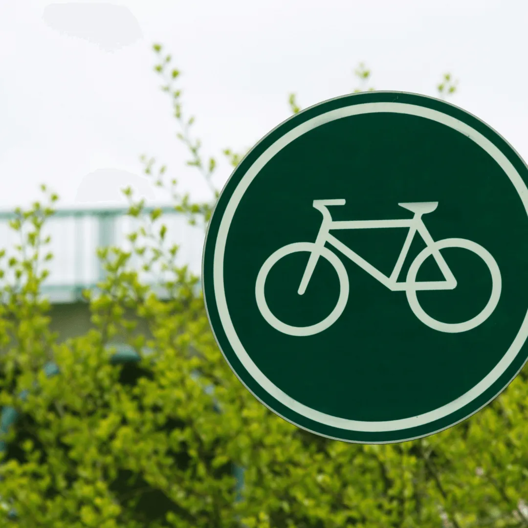 Panneau vert et blanc indiquant une direction ou une information, placé dans un environnement extérieur.