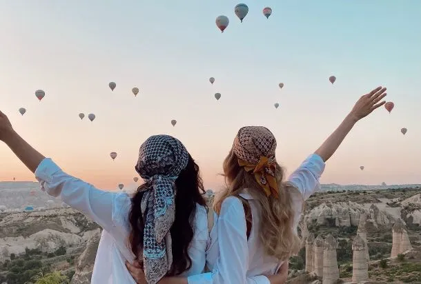 Deux femmes faisant face à un ciel rempli de montgolfière