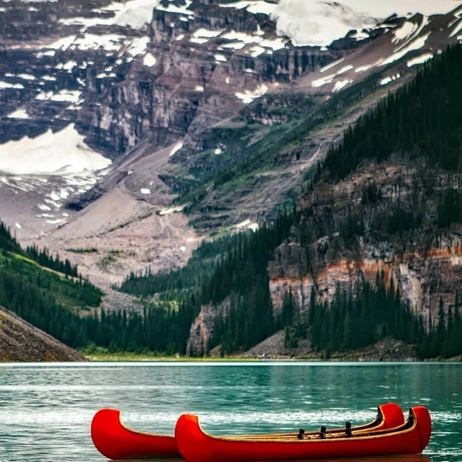 Un canoë sur le lac Louise, dans le parc national de Banff, Alberta, Canada, entouré de montagnes majestueuses.