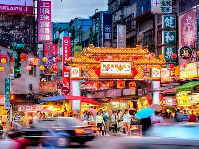 A lively street with many people walking in different directions, creating a dynamic atmosphere.