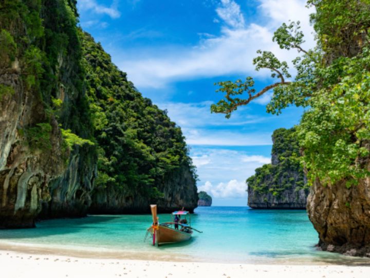 Idyllic Thai beaches with turquoise waters, white sand, and lush greenery under a clear blue sky.