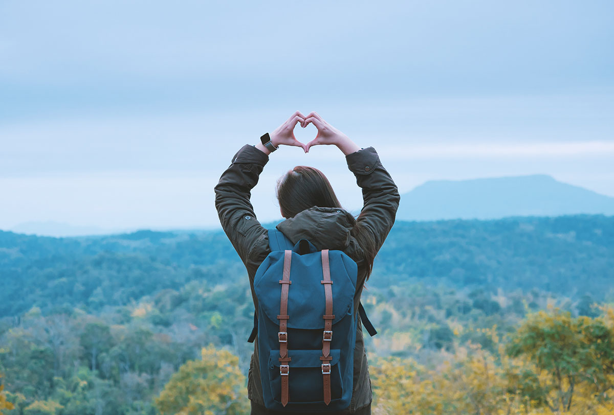 Image d'un voyageur faisant le symbole du coeur d'amour avec ses mains