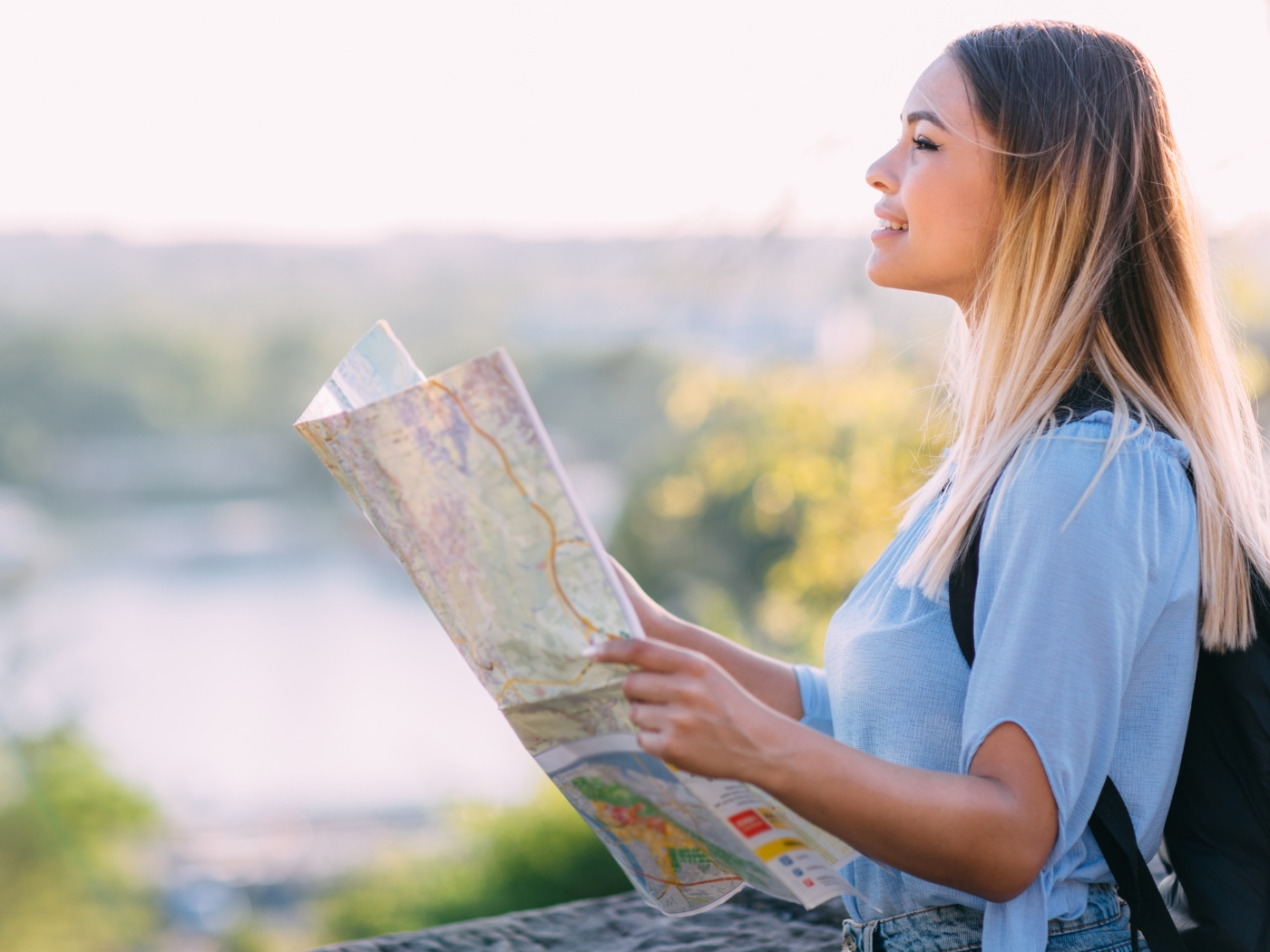 A woman holding a map and looking straight